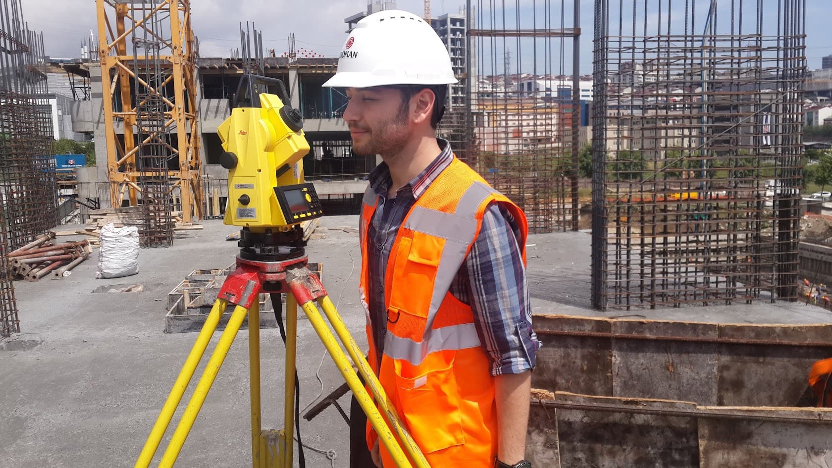A person using a theodolite on a construction site, symbolizing precision in architecture and engineering.